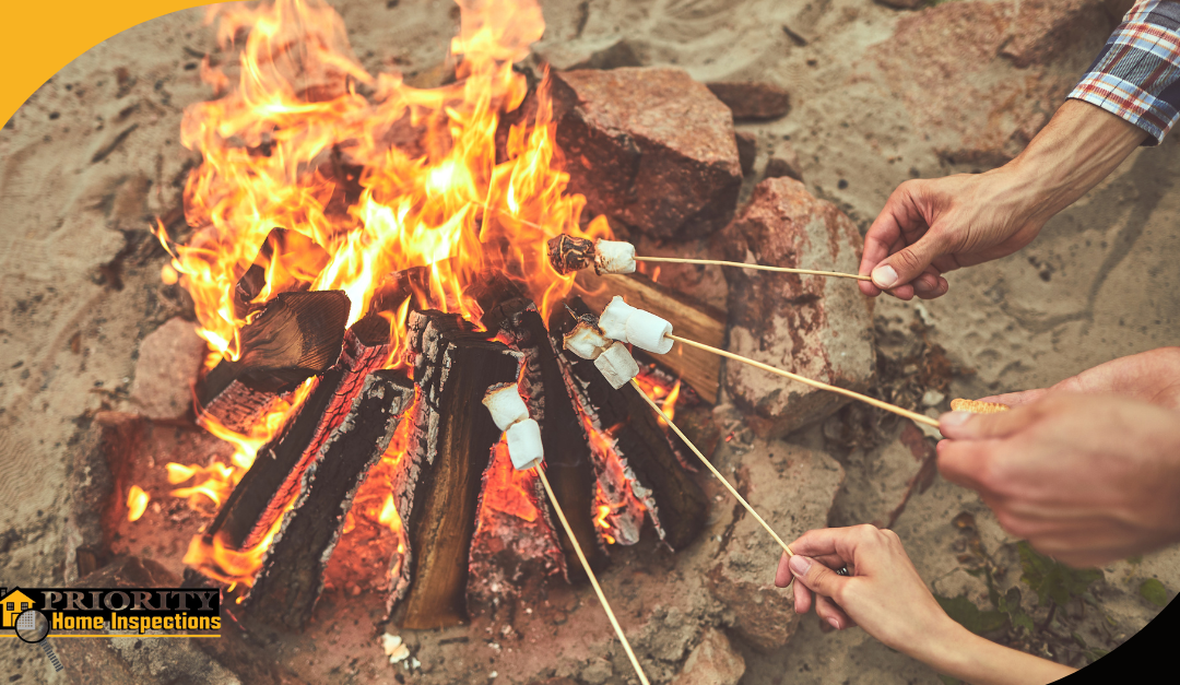 Hands roasting marshmallows over a campfire during an outdoor gathering